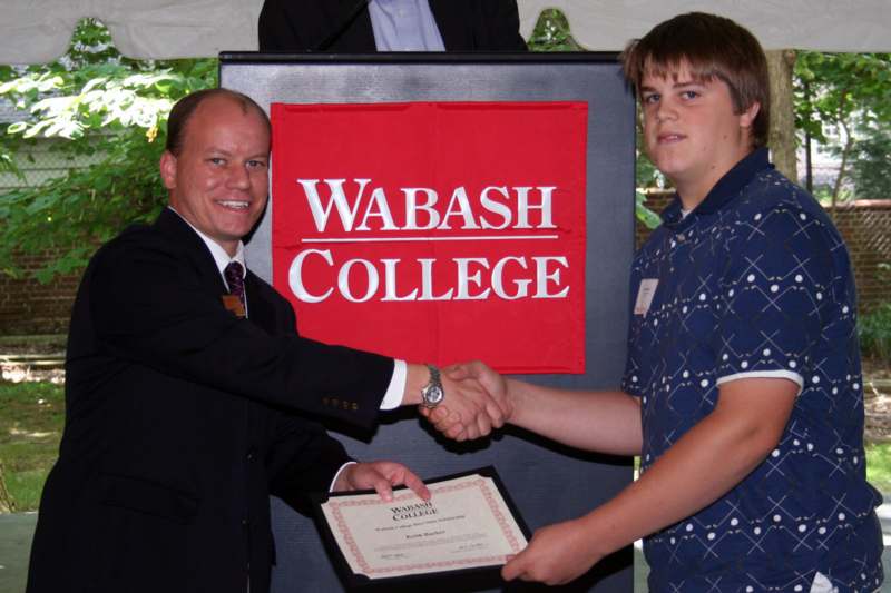 a man shaking hands with a man in a suit