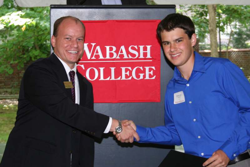 a man shaking hands with a young man