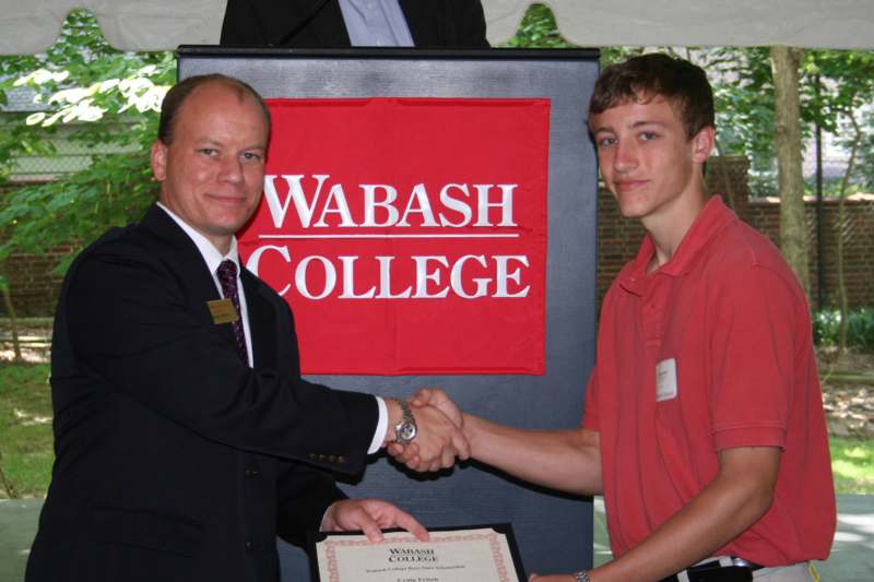 a man shaking hands with a young man