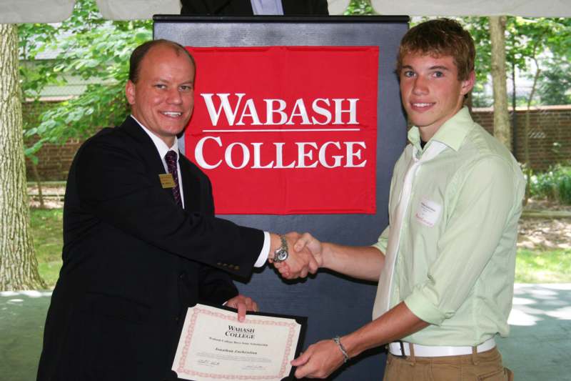 a man shaking hands with a man in a suit