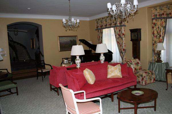 a living room with a red couch and a piano