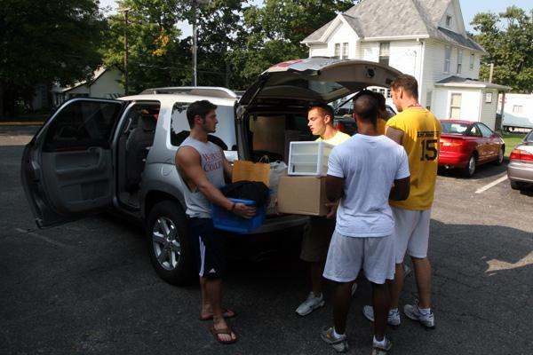 a group of men unloading boxes from a van