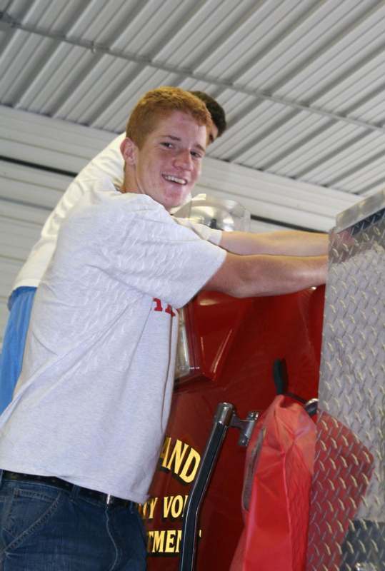a young man leaning on a fire truck