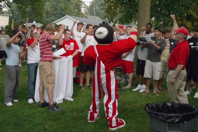 a group of people watching a boy in a red and white striped outfit