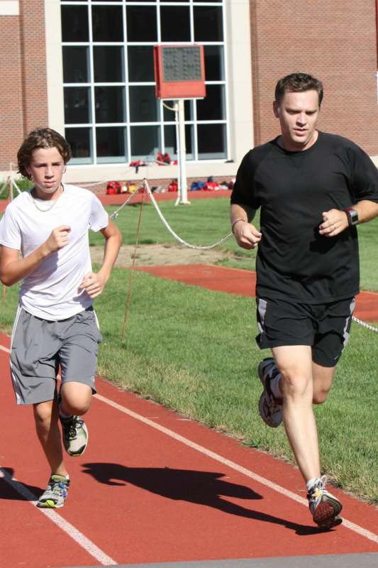 a man and boy running on a track