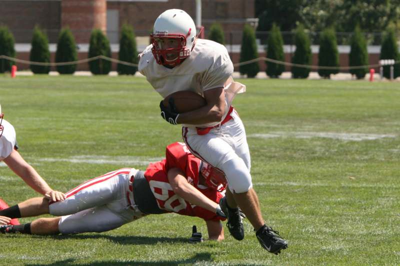 a football player falling off of another football player