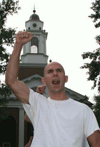 a man raising his fist in front of a church