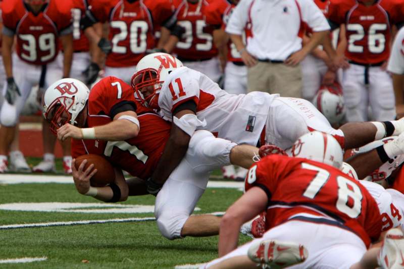a football player being tackled by a group of men