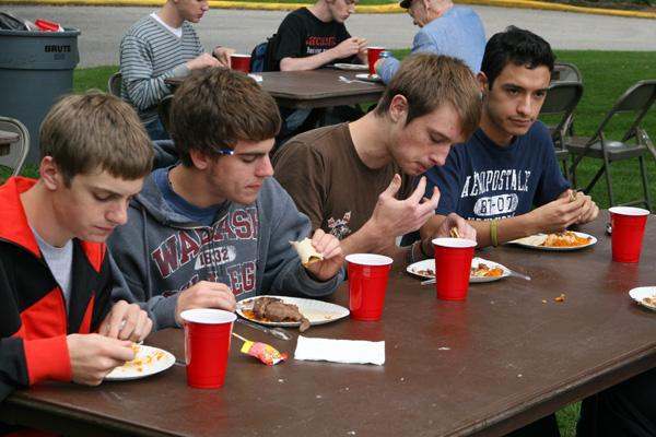 a group of young men eating at a table