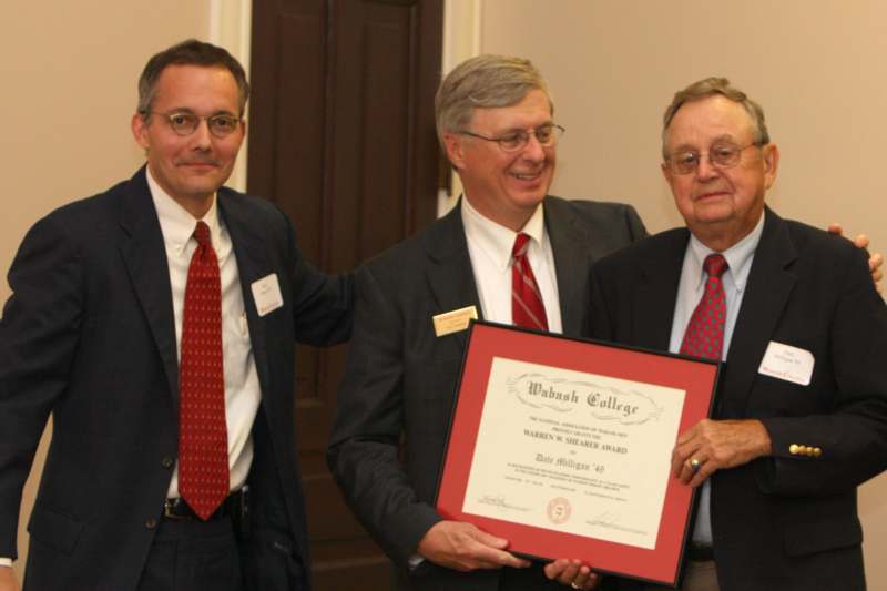 men in suits holding a certificate