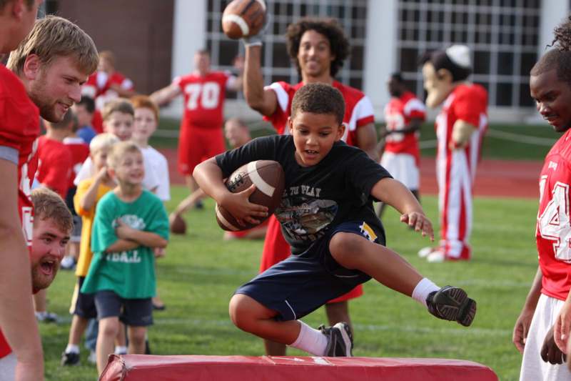 a boy jumping with footballs in the air