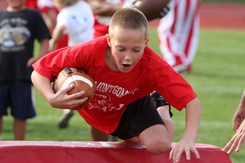 a boy in a red shirt holding a football