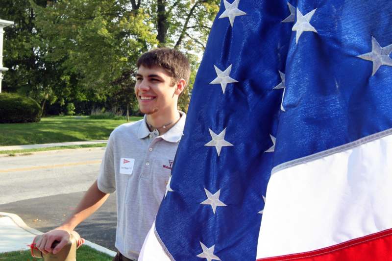 a man standing next to a flag
