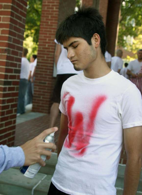 a man with red spray paint on his shirt