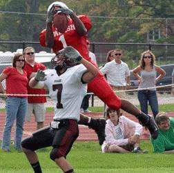 a football player jumping over another football player