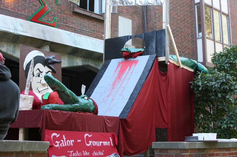 a red and black tent with a green statue and a red banner