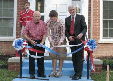 a group of men cutting a ribbon