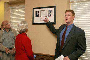 a man pointing at a framed picture
