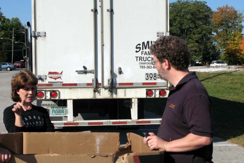 a man and woman standing next to a truck