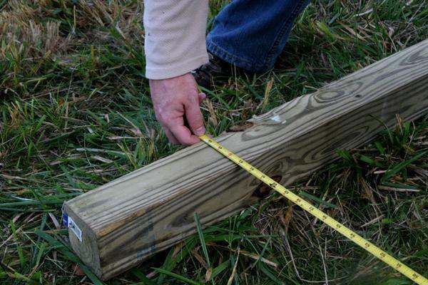 a person measuring a piece of wood