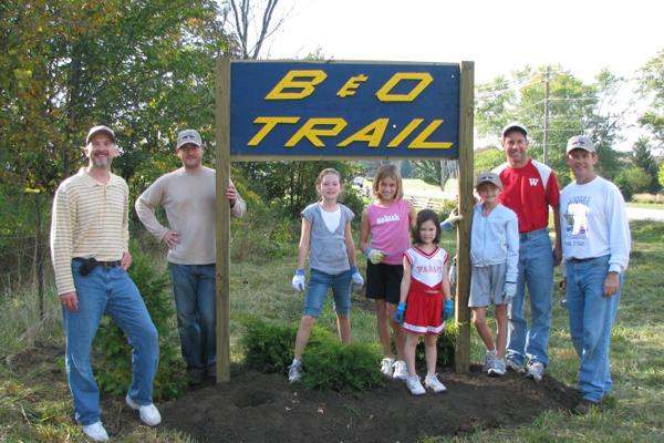 a group of people standing next to a sign