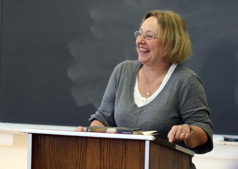 a woman smiling at a podium