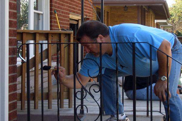 a man painting a railing