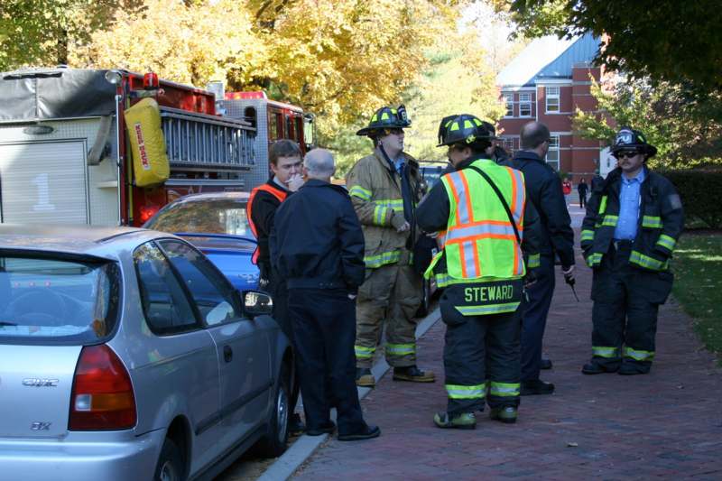 a group of firefighters standing on a sidewalk
