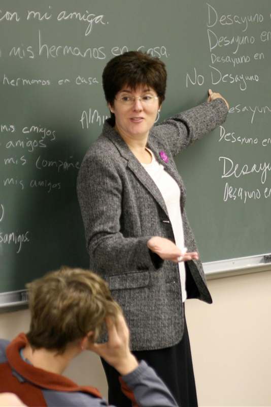 a woman writing on a chalkboard