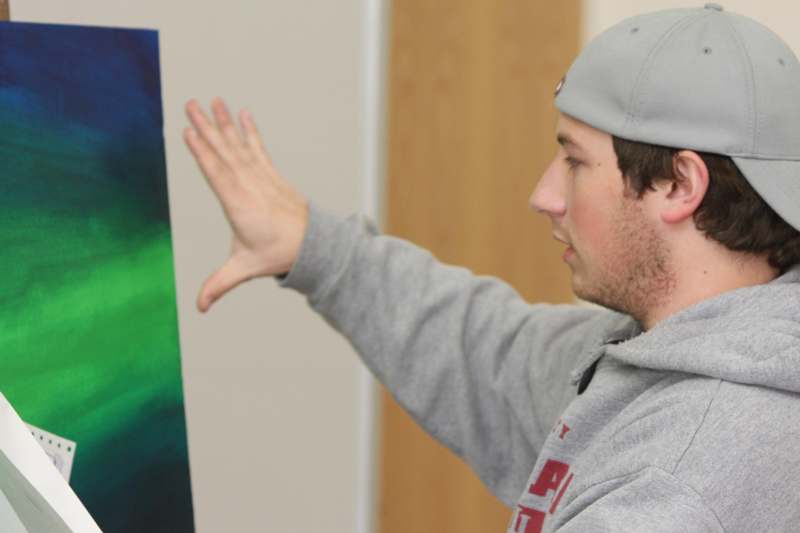 a man holding a piece of art