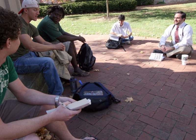 a group of men sitting on a brick surface