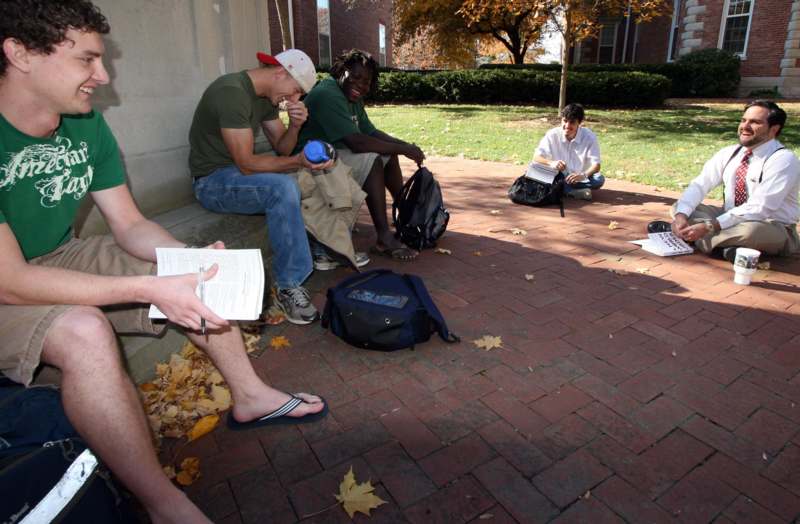 a group of people sitting on a brick sidewalk