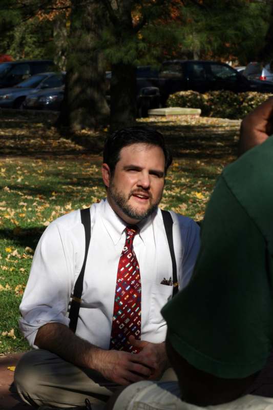 a man in suspenders and a red tie