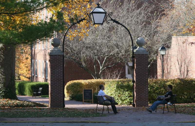 a man sitting on a bench under a archway