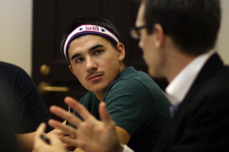 a man wearing a headband talking to another man