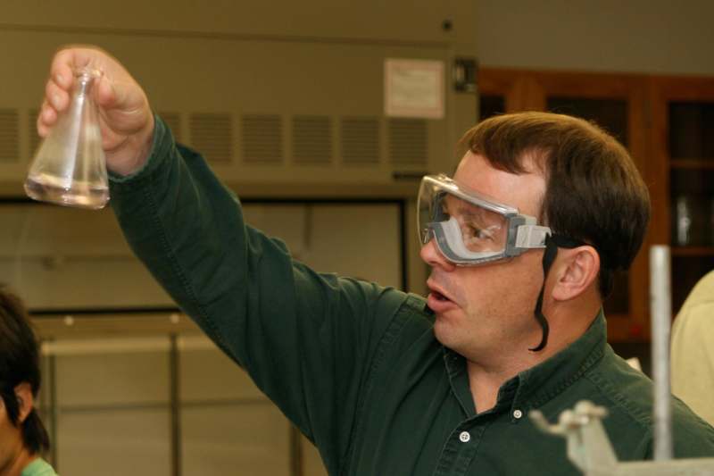 a man wearing safety goggles pointing at something