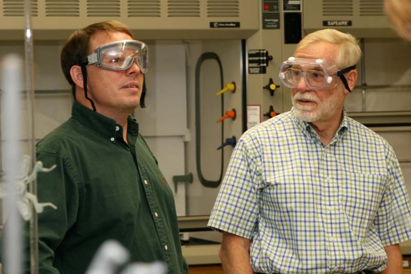 a man wearing safety goggles and looking at another man
