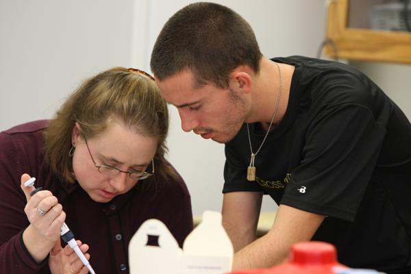 a man and woman looking at a pipette