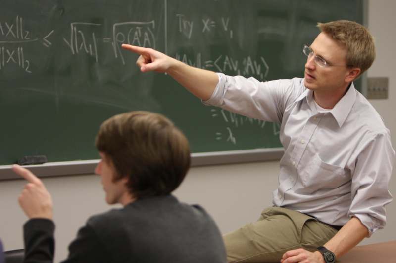 a man pointing at a chalkboard