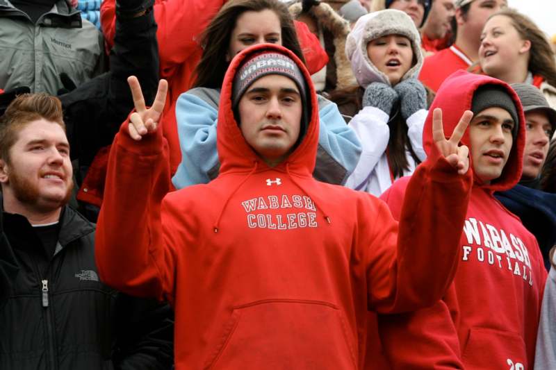 a man in a red hoodie holding up two fingers