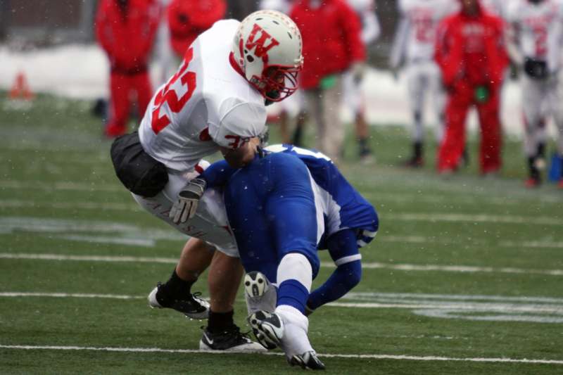 a football player falling over another player