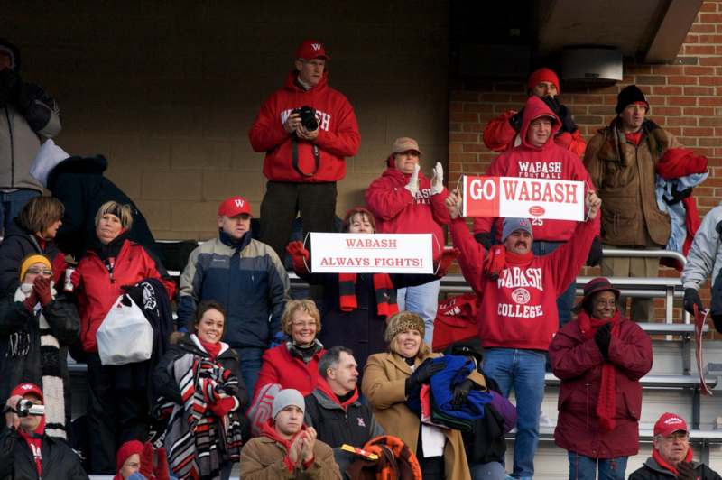 a group of people in red jackets holding signs