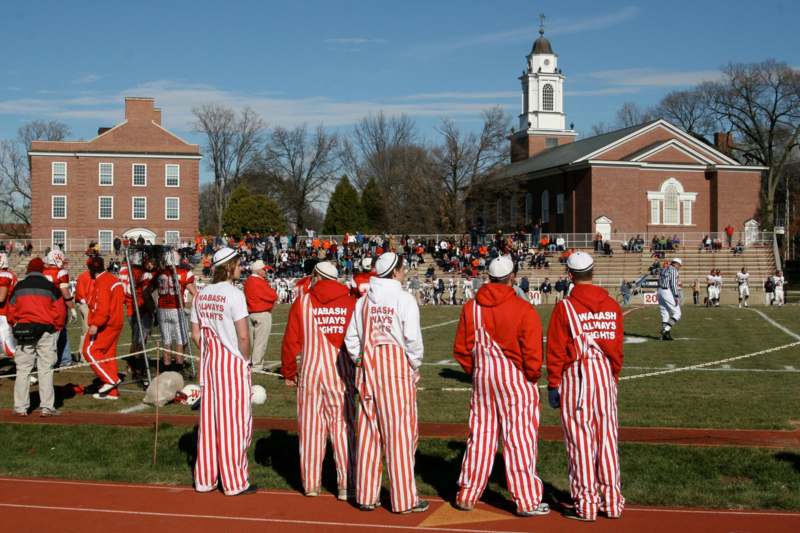 a group of people in striped overalls on a field