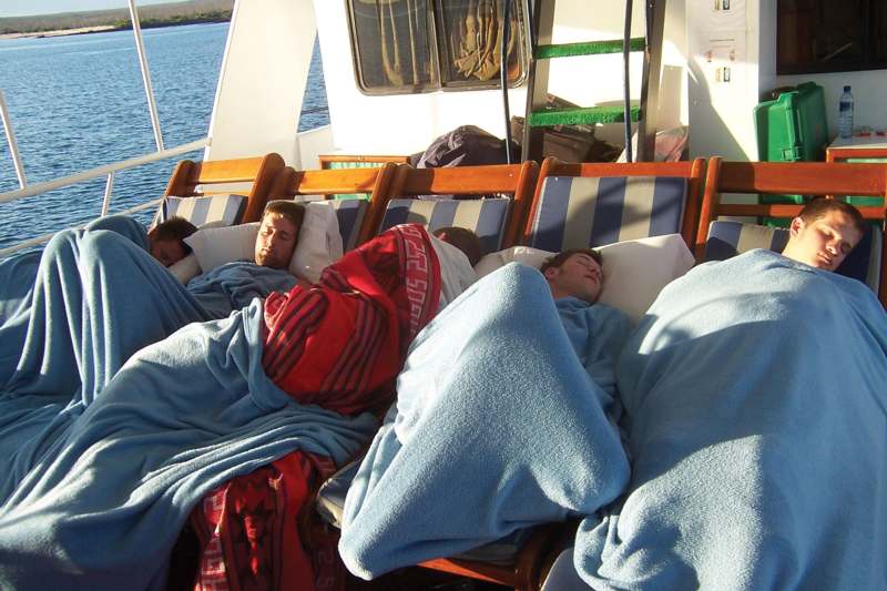 several people sleeping on a boat