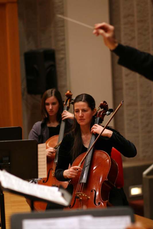 a group of people playing cellos