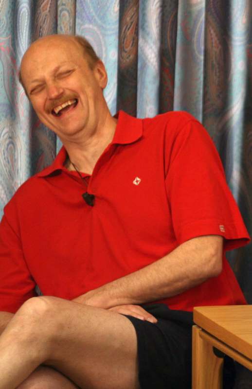 a man laughing with his eyes closed