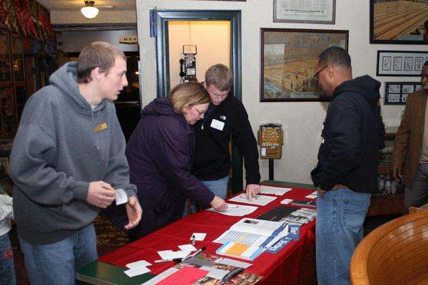 a group of people looking at papers on a table