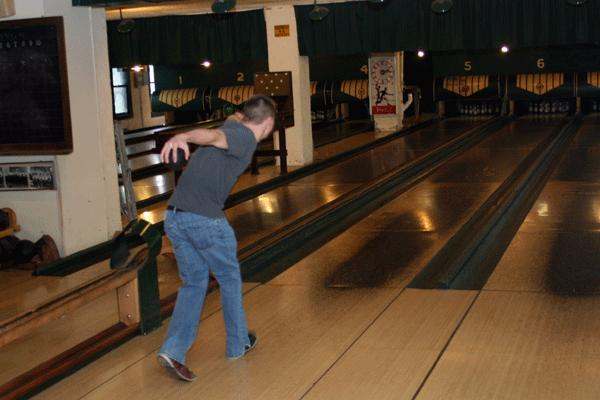 a man throwing a bowling ball
