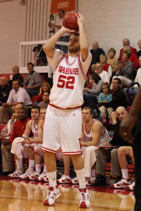 a basketball player in a white uniform with his hands up