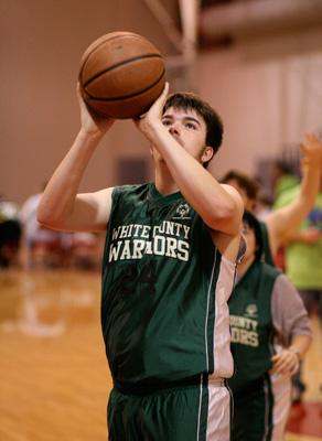 a young man shooting a basketball